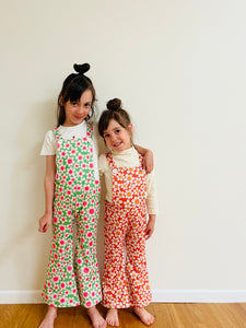 two girls wearing 70s retro style bell bottom flower power overalls