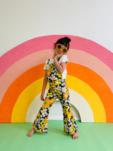 Load image into Gallery viewer, cute kid wearing black flower power groovy overalls 