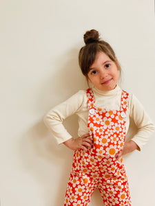 cute toddler girl wearing flower power overalls 