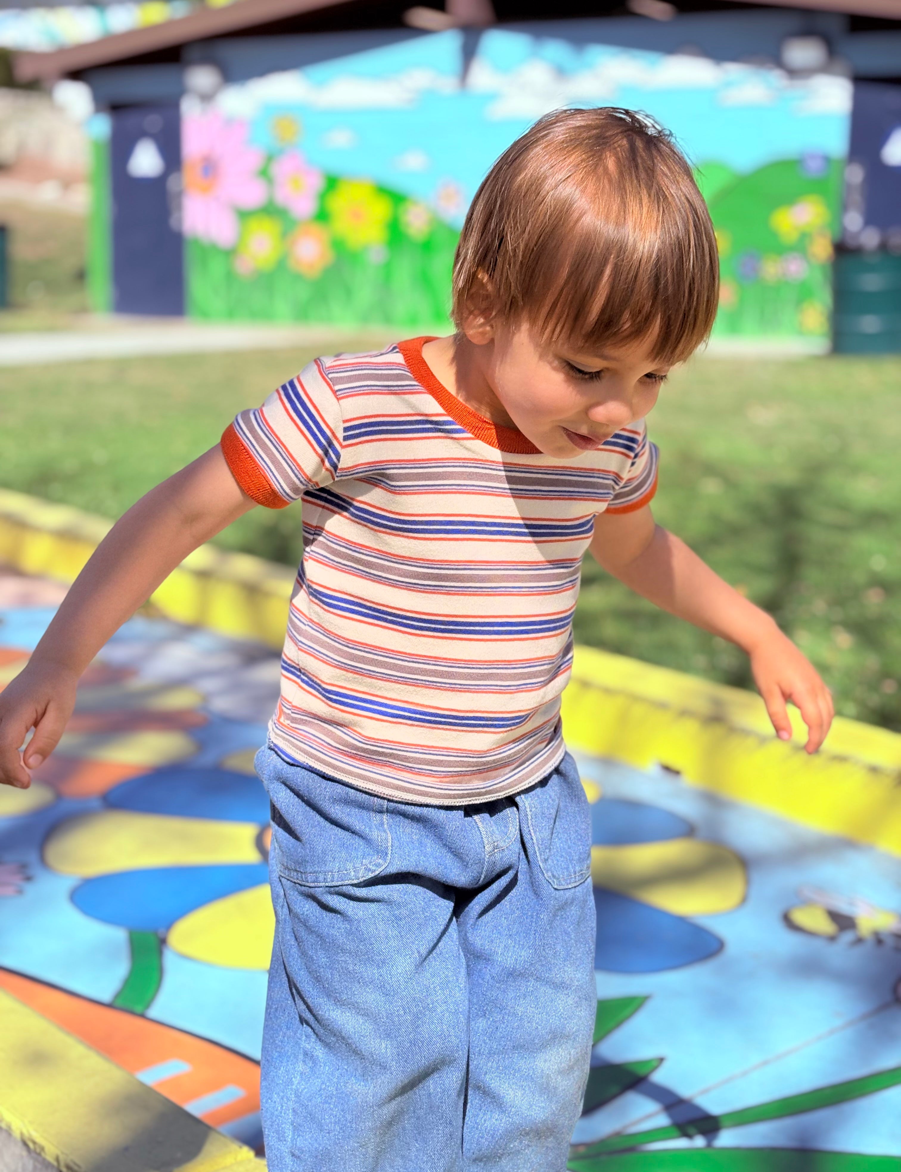 cute toddler boy wearing retro ringer tee on colorful playground
