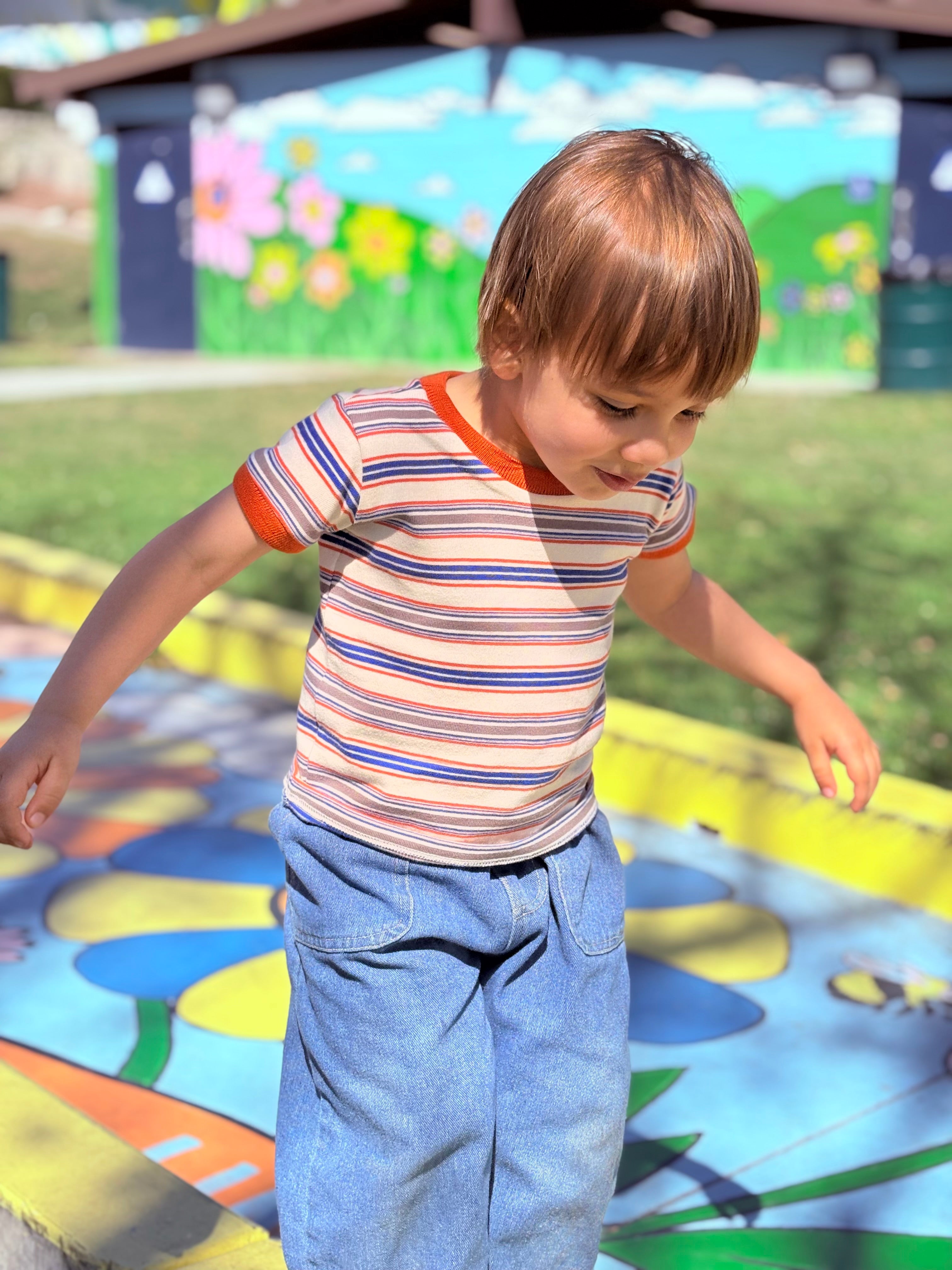 cute toddler boy wearing retro ringer tee on colorful playground