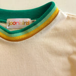 Close-up of a shirt with a colorful collar and 'joonbird' label on a beige background