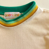 Close-up of a shirt with a colorful collar and 'joonbird' label on a beige background