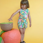 girl wearing colorful cute floral matching summer outfit with yellow background 