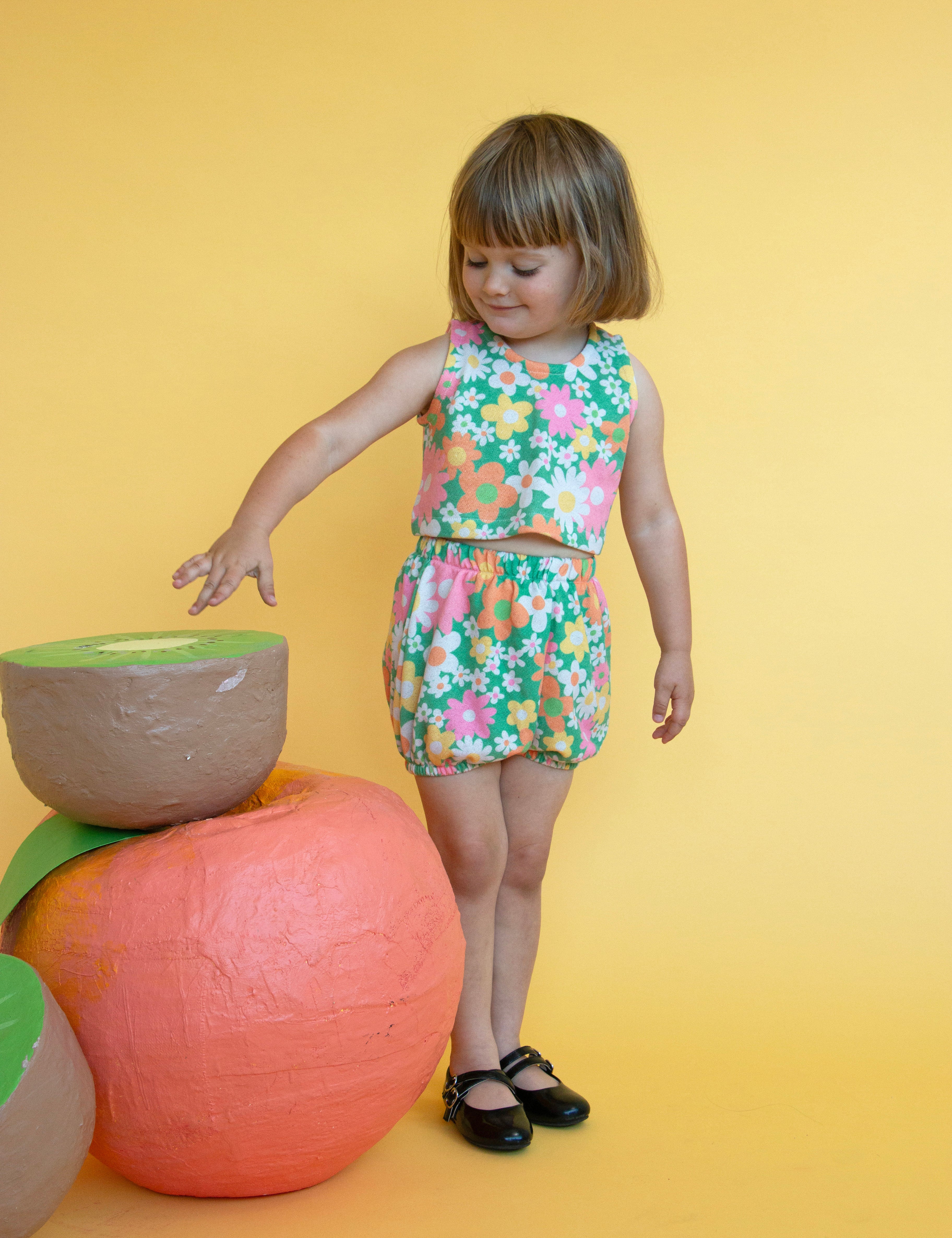 girl wearing colorful cute floral matching summer outfit with yellow background 