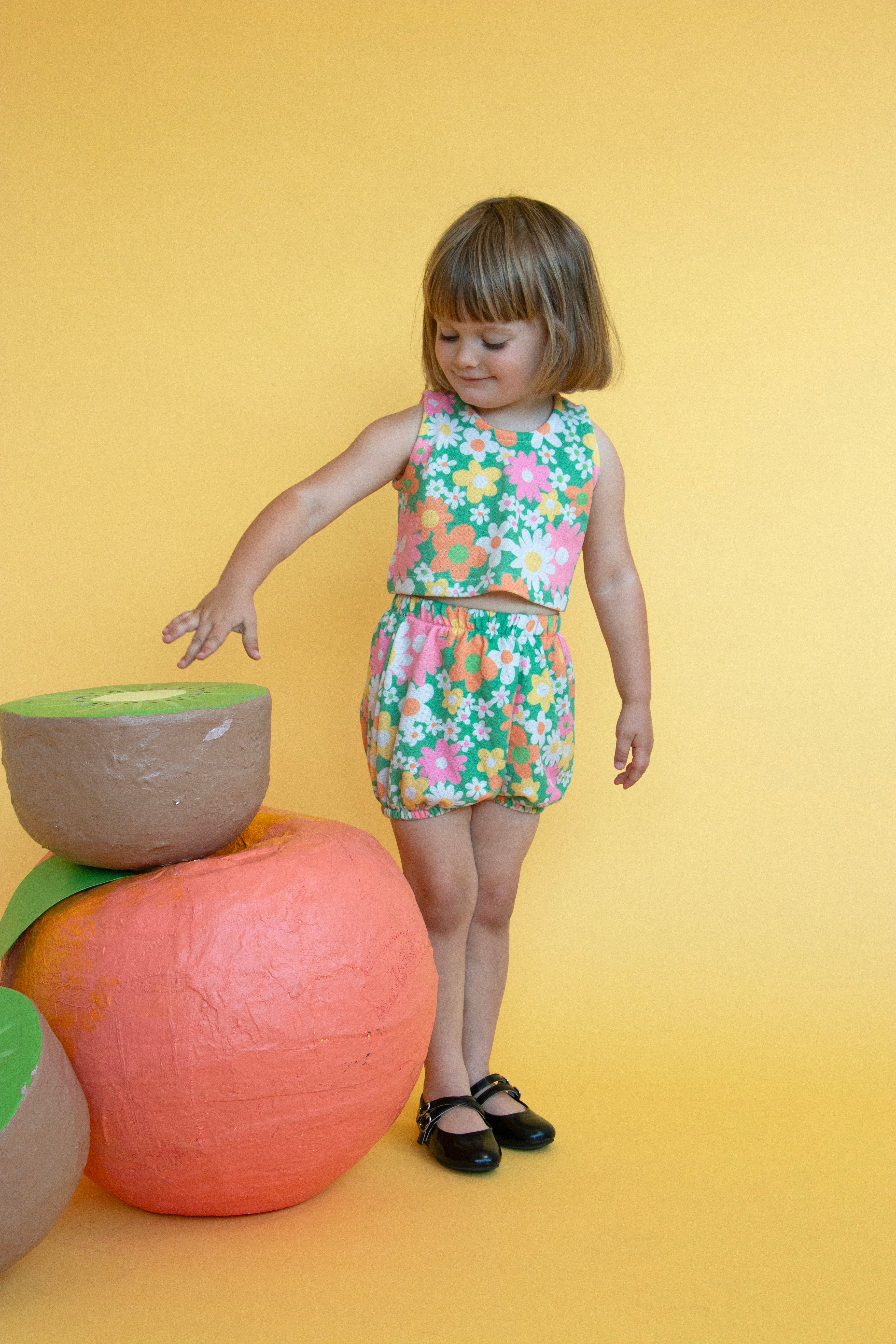 girl wearing colorful cute floral matching summer outfit with yellow background 
