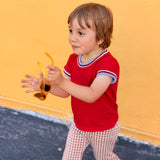 child wearing vintage tee groovy outfit in front of yellow wall