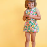 toddler girl wearing vintage inspired colorful flower power matching set with yellow background 
