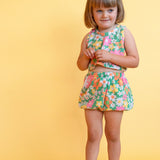 toddler girl wearing vintage inspired colorful flower power matching set with yellow background 