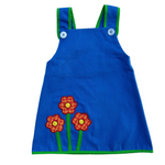 girls vintage inspired blue a-line dress with flower patches on a white background