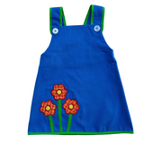 girls vintage inspired blue a-line dress with flower patches on a white background