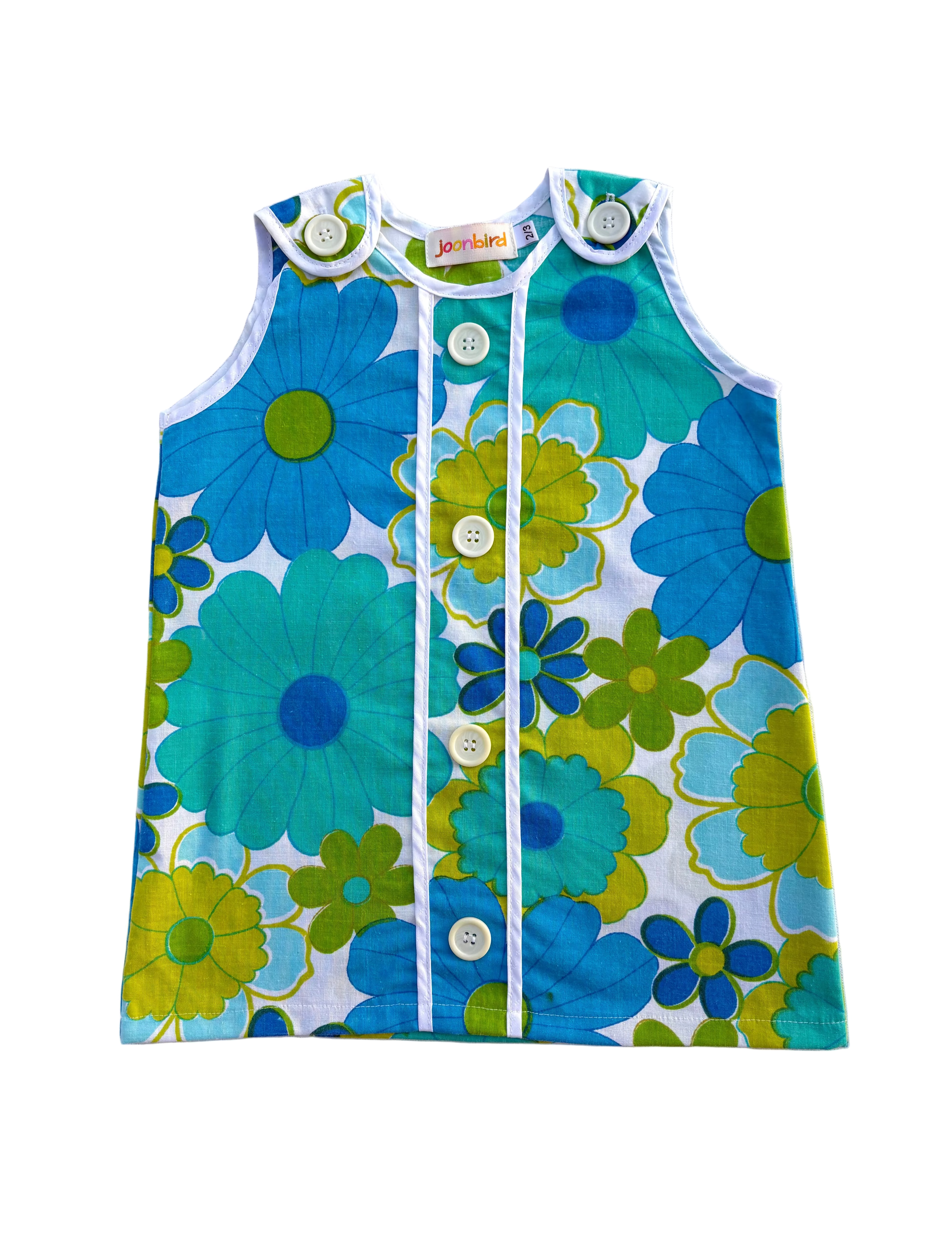girls 70s style flower power dress with blue and green flowers on a white background