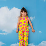 girl wearing cute retro pants set outfit with pink flowers on yellow background with sky backdrop