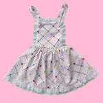Children's dress with colorful geometric pattern on a pink background