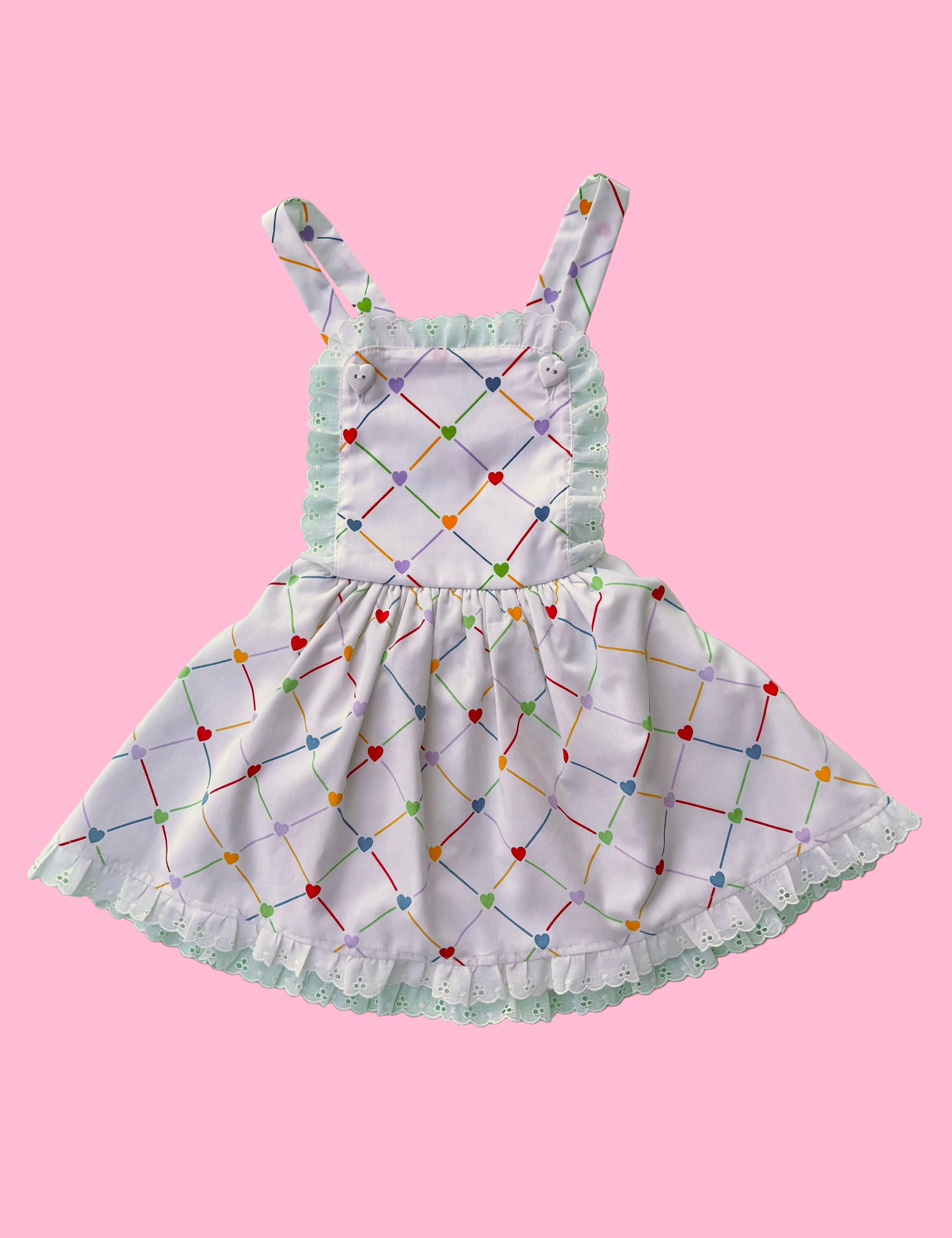 Children's dress with colorful geometric pattern on a pink background