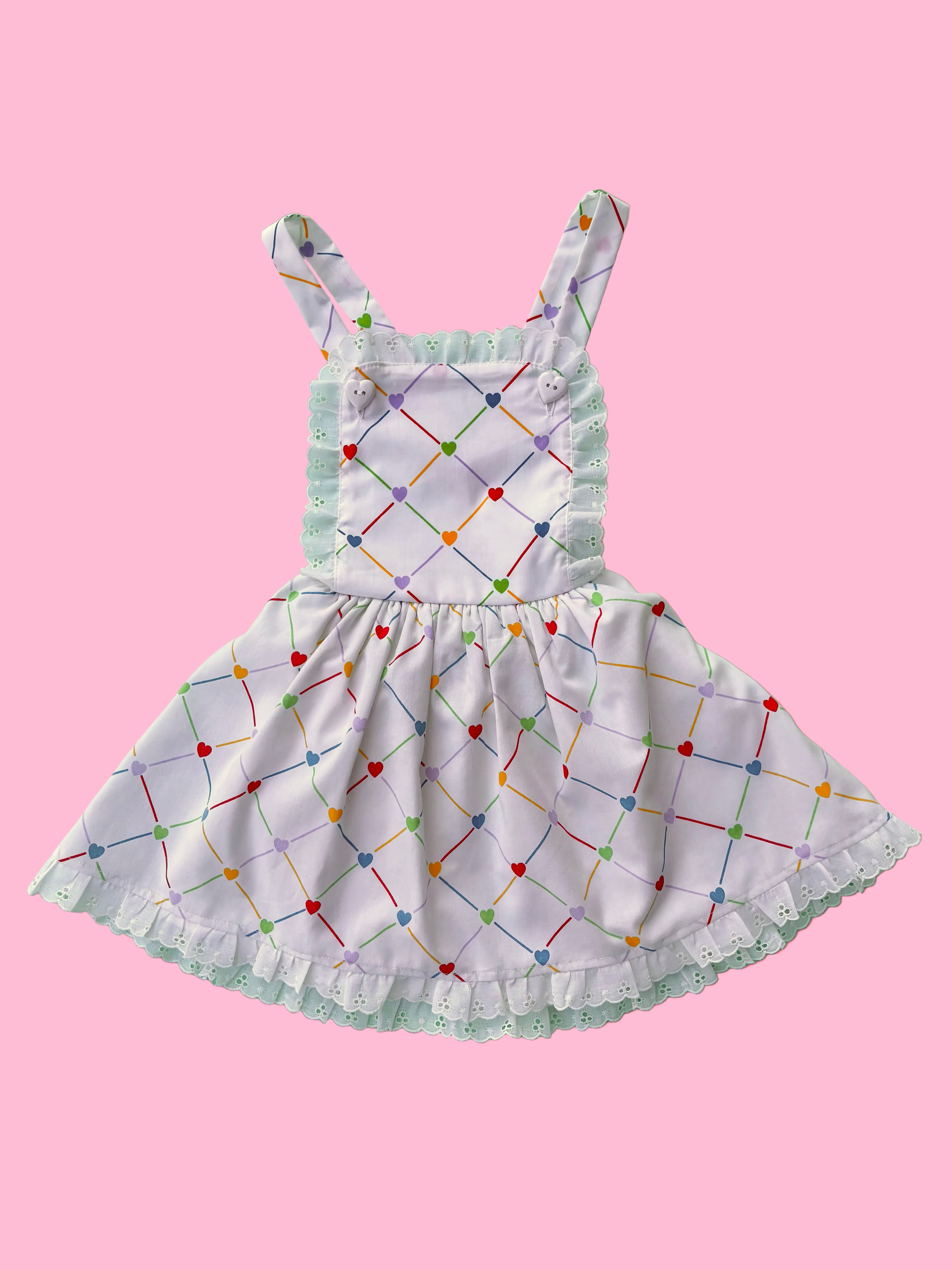 Children's dress with colorful geometric pattern on a pink background