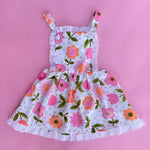 vintage inspired pink floral flower power girls pinafore dress with pink backdrop 