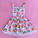 vintage inspired pink floral flower power girls pinafore dress with pink backdrop 